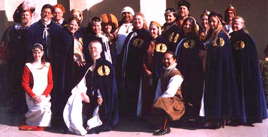 A group of people wearing blue velvet order robes with laurel wreath.