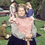 A full body photo of Mistress Louise, wearing Elizabethan style clothing.